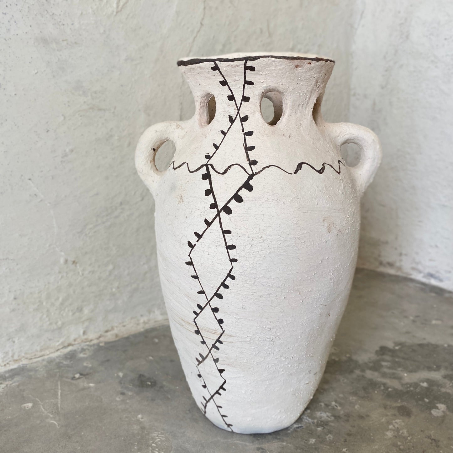 cream colored vessel with black painted lines