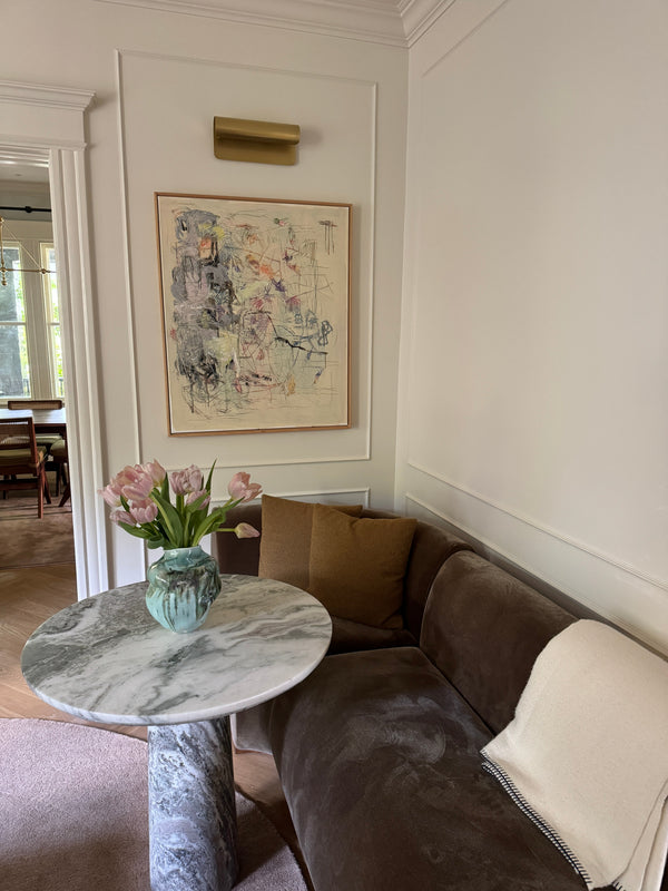 picture of living room with vase, art, sofa, blanket 