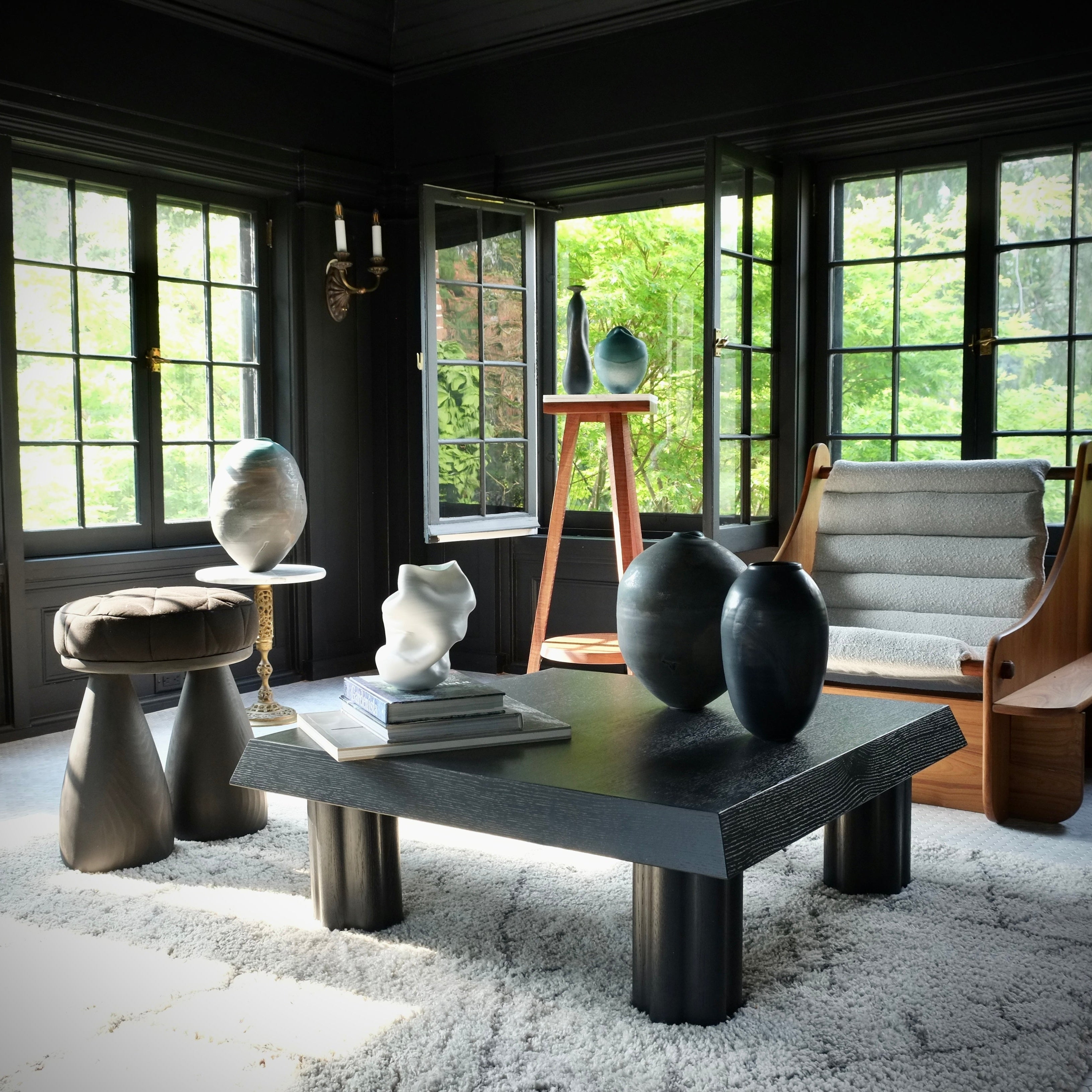 Modern living room with dark coffee table, gray sofa, and decorative vases.