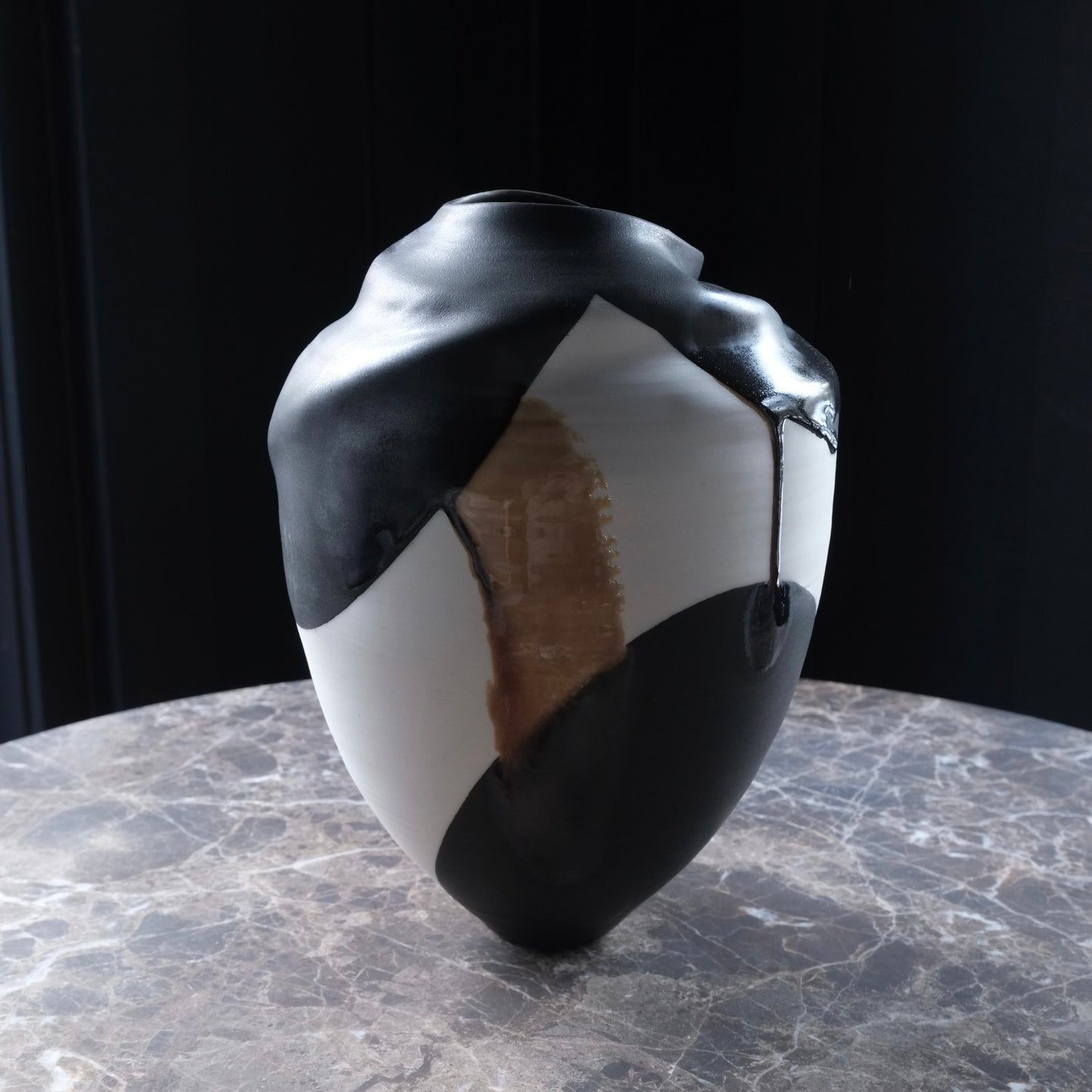 Black and white ceramic vase with a unique design on a marble surface