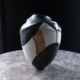 Black and white ceramic vase with a unique design on a marble surface