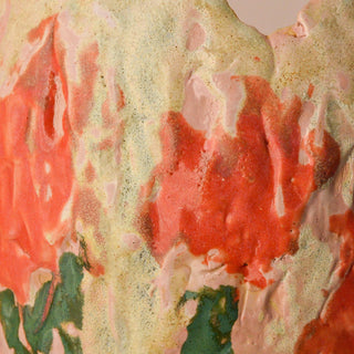 Close-up of a textured surface with red and green patterns on a beige background