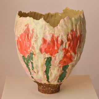 Ceramic vase with textured surface and red floral patterns on a beige background